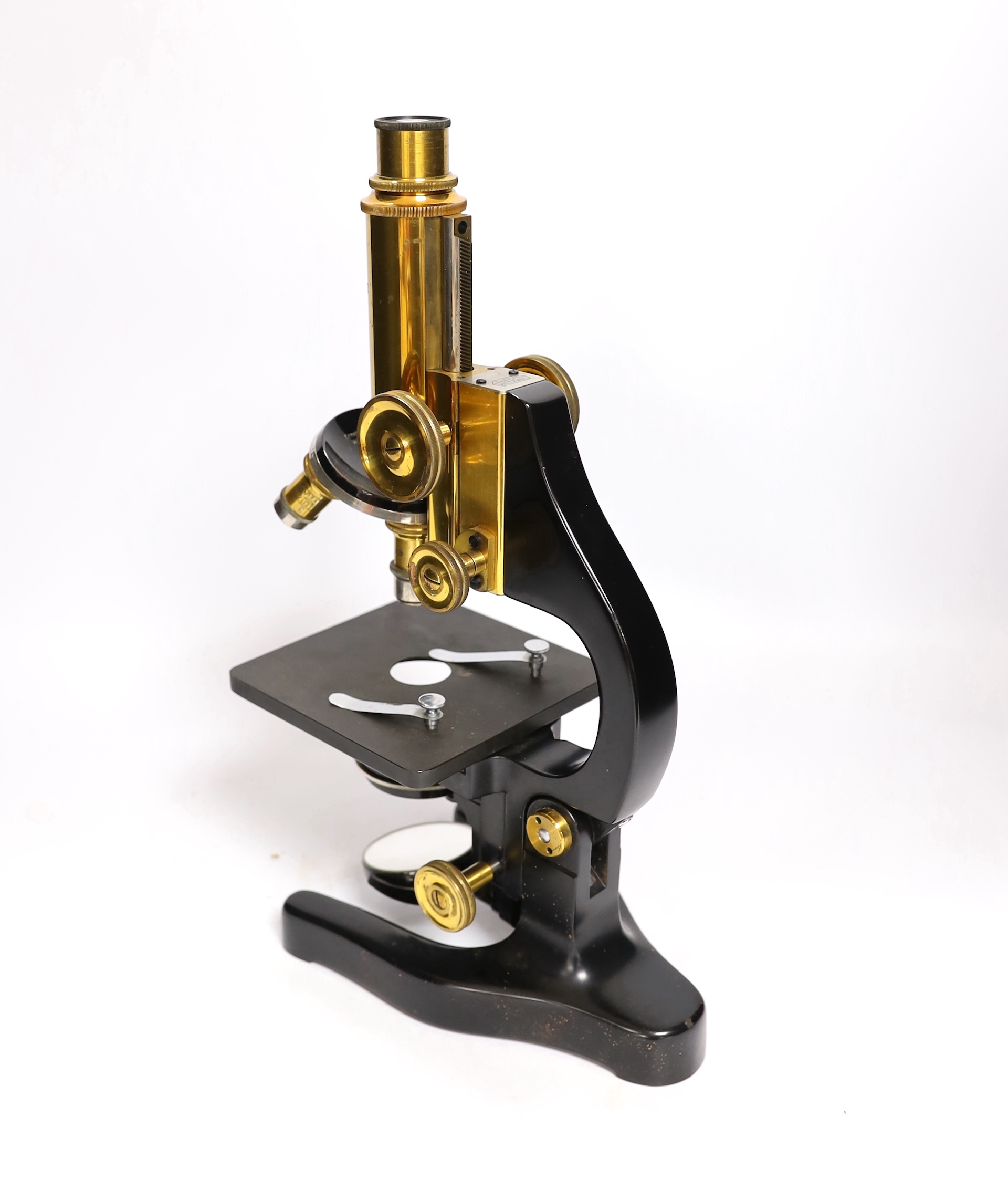 An early 20th century Leitz microscope in a teak case, with alternative lenses, card inserts and sliding compartment with glass slides, matching serial numbers stamped onto case and on magnification table